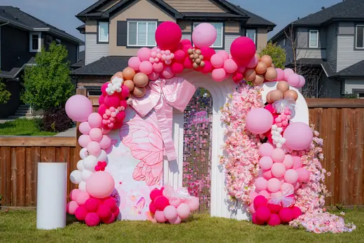 Outdoor pink floral proposal and balloon backdrop