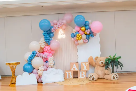 Pastel baby shower balloon display with teddy bear details
