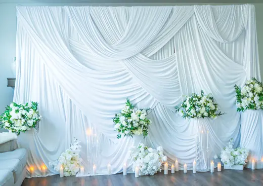 White draped floral event stage