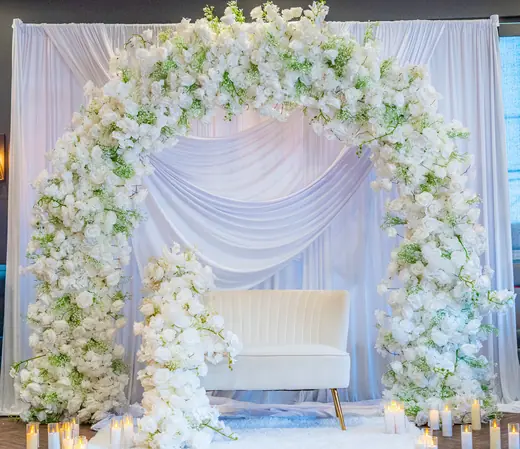 White floral wedding arch with soft draping