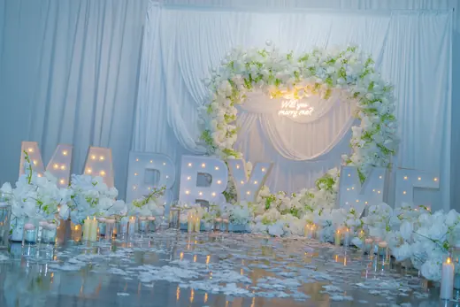White floral marriage proposal backdrop with candles