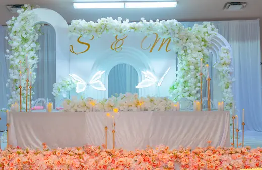 White and gold floral event stage with candlelight